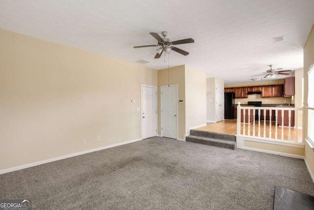 40 Wimberly Way, Covington, GA 30016 - unfurnished living room featuring ceiling fan, light colored carpet, baseboards, and a sink