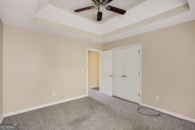40 Wimberly Way, Covington, GA 30016 - unfurnished bedroom featuring a raised ceiling, carpet floors, baseboards, and a ceiling fan