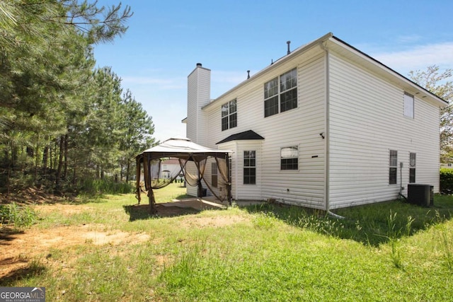 40 Wimberly Way, Covington, GA 30016 - back of property with a gazebo, central AC, and a chimney