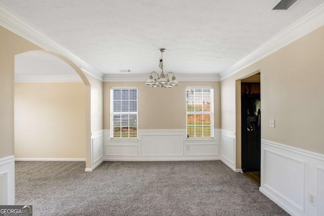 40 Wimberly Way, Covington, GA 30016 - unfurnished dining area with a wainscoted wall, a chandelier, arched walkways, carpet, and crown molding