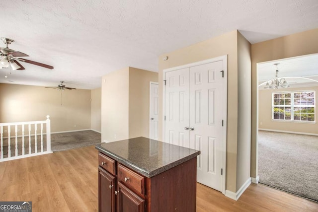 40 Wimberly Way, Covington, GA 30016 - kitchen with open floor plan, a chandelier, baseboards, a ceiling fan, and a center island