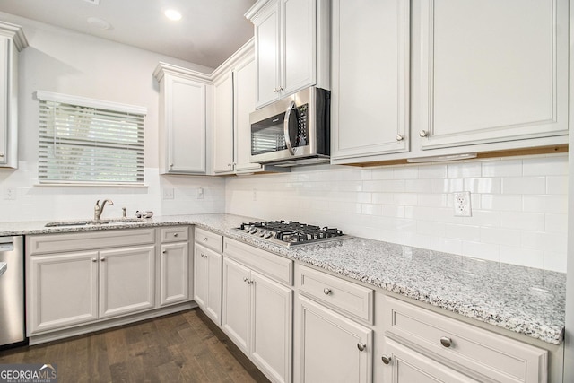 206 Brookview Dr, Newnan, GA 30265 - kitchen with appliances with stainless steel finishes, a sink, dark wood-type flooring, backsplash, and light stone countertops