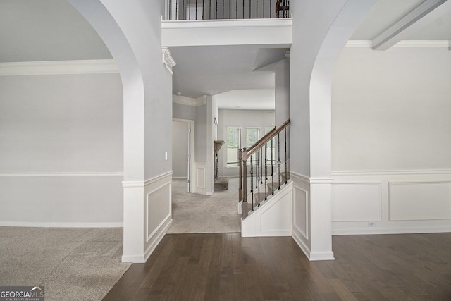 206 Brookview Dr, Newnan, GA 30265 - foyer entrance with crown molding, arched walkways, dark wood-style floors, stairway, and wainscoting
