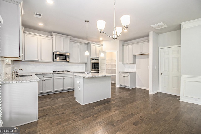206 Brookview Dr, Newnan, GA 30265 - kitchen featuring stainless steel microwave, a sink, decorative backsplash, a center island, and gas stovetop