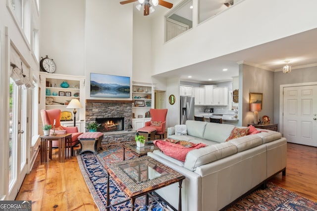 61 Deer Run Rdg, Big Canoe, GA 30143 - living room featuring a high ceiling, light wood finished floors, a fireplace, ceiling fan, and crown molding