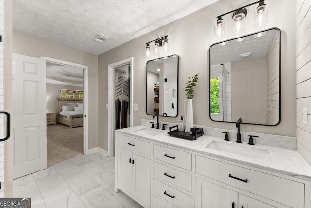 6520 Glen Pond Trce, Cumming, GA 30028 - full bathroom with marble look tile flooring, double vanity, baseboards, a textured ceiling, and ensuite bathroom