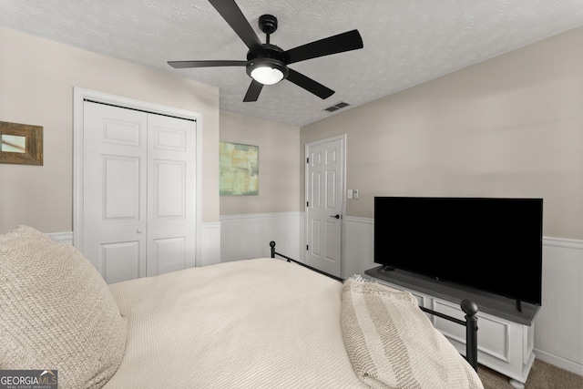 6520 Glen Pond Trce, Cumming, GA 30028 - carpeted bedroom with a wainscoted wall, a closet, a textured ceiling, and ceiling fan