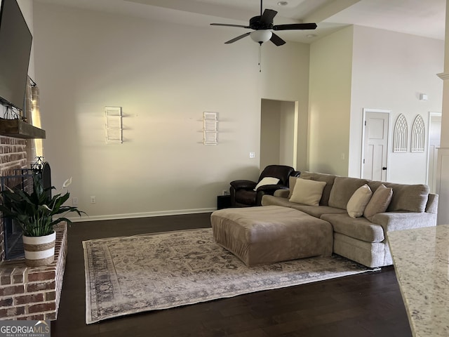 216 Springdale Estates Dr, Senoia, GA 30276 - living area with a high ceiling, a ceiling fan, dark wood finished floors, a brick fireplace, and baseboards
