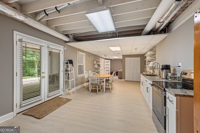 420 Windswept Ct, Roswell, GA 30075 - kitchen with stainless steel range with electric cooktop, a sink, light wood-style flooring, stone counters, and baseboards