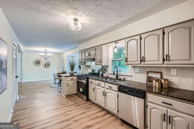 9 Windsor Way, Newnan, GA 30263 - kitchen with appliances with stainless steel finishes, a sink, a peninsula, a textured ceiling, and a chandelier