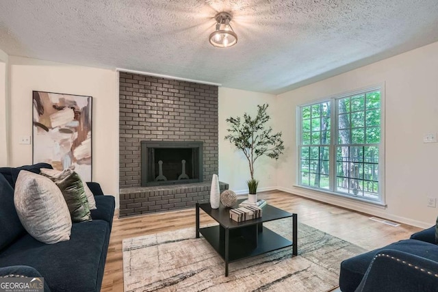 9 Windsor Way, Newnan, GA 30263 - living area featuring a textured ceiling, wood finished floors, baseboards, and a brick fireplace