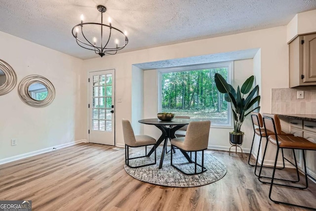 9 Windsor Way, Newnan, GA 30263 - dining room with light wood-style floors, a chandelier, a textured ceiling, and baseboards