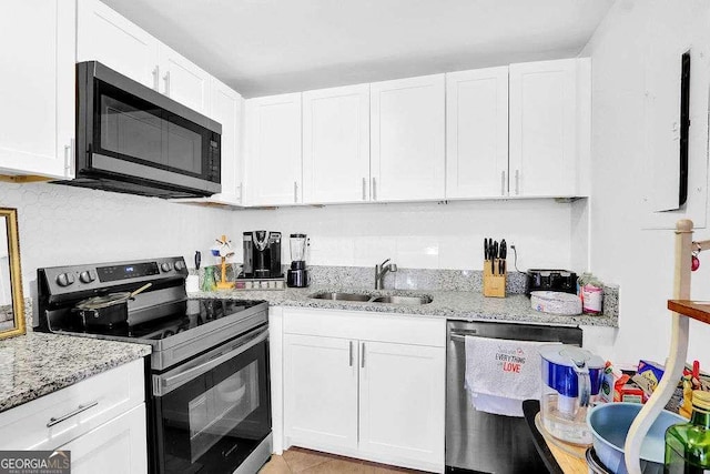 1150 Rankin St Unit 19O, Stone Mountain, GA 30083 - kitchen featuring appliances with stainless steel finishes, a sink, white cabinetry, and light stone counters