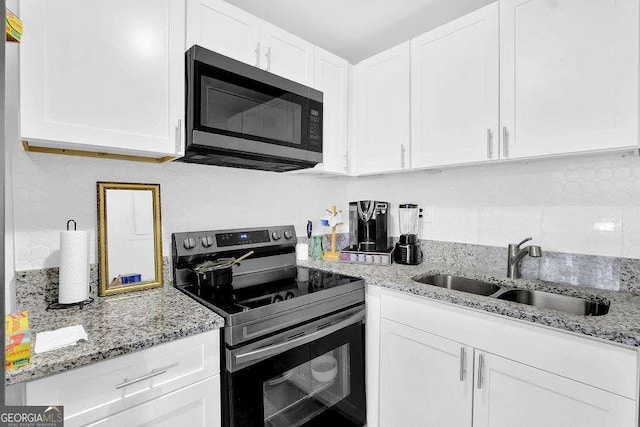 1150 Rankin St Unit 19O, Stone Mountain, GA 30083 - kitchen with stainless steel microwave, electric stove, a sink, white cabinets, and light stone counters