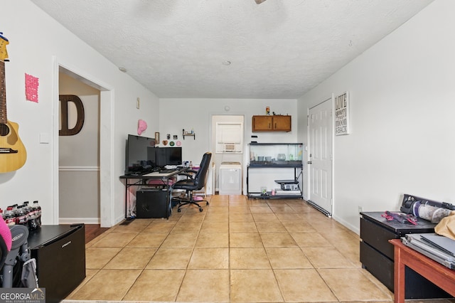 home office with washer / clothes dryer, light tile patterned floors, baseboards, and a textured ceiling