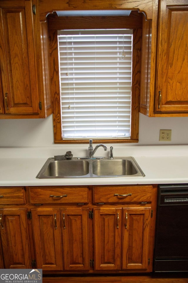 298 S Main St, Baxley, GA 31513 - kitchen featuring black dishwasher, a sink, light countertops, and brown cabinetry