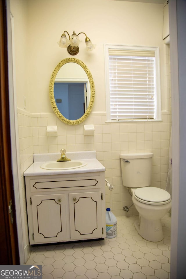 298 S Main St, Baxley, GA 31513 - bathroom with tile walls, vanity, toilet, tile patterned flooring, and wainscoting