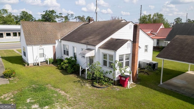 298 S Main St, Baxley, GA 31513 - back of property with entry steps, central air condition unit, a shingled roof, a chimney, and a lawn