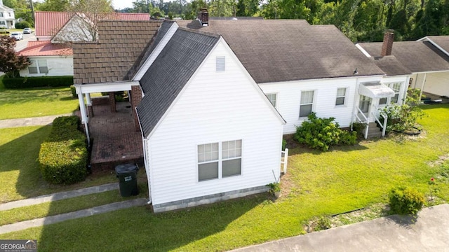 298 S Main St, Baxley, GA 31513 - view of home's exterior featuring a chimney and a yard