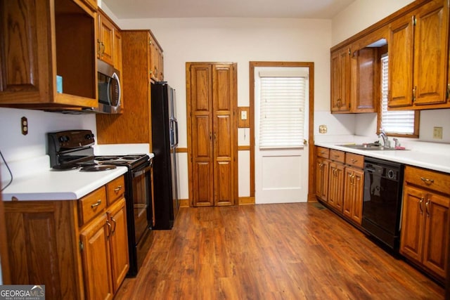 298 S Main St, Baxley, GA 31513 - kitchen featuring black appliances, a sink, light countertops, and dark wood-style floors