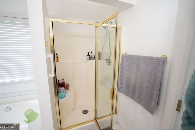 bathroom with a stall shower and a garden tub