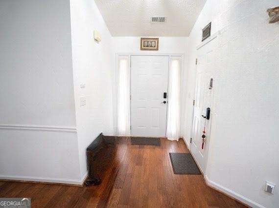 doorway featuring wood finished floors and baseboards