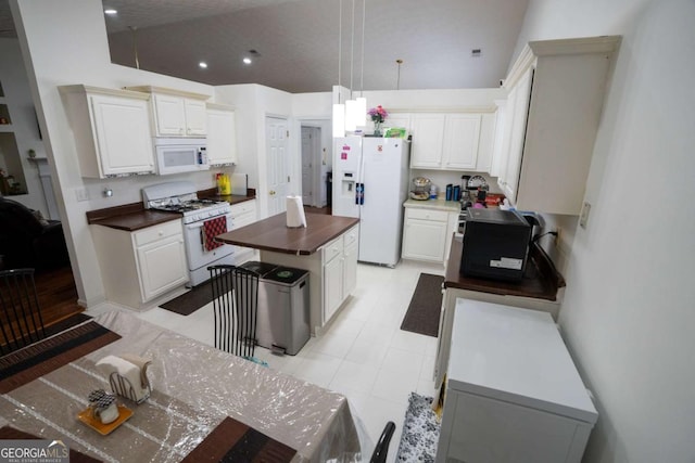 kitchen with white appliances, a kitchen island, recessed lighting, hanging light fixtures, and white cabinetry