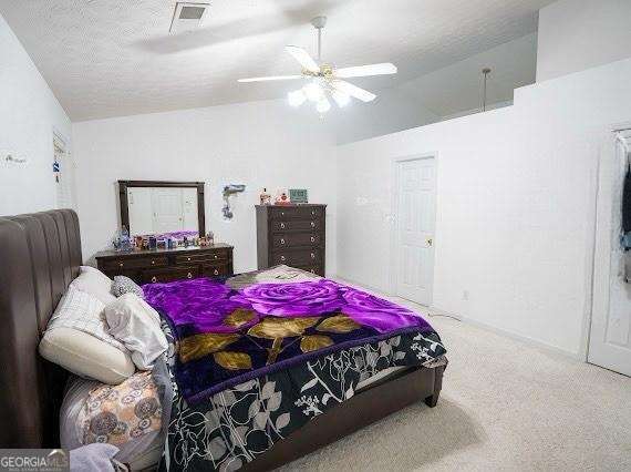 carpeted bedroom featuring lofted ceiling and a ceiling fan