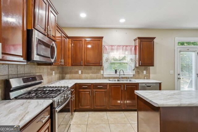 1520 Ethans Way, Mcdonough, GA 30252 - kitchen featuring stainless steel appliances, a sink, backsplash, light tile patterned flooring, and light stone counters
