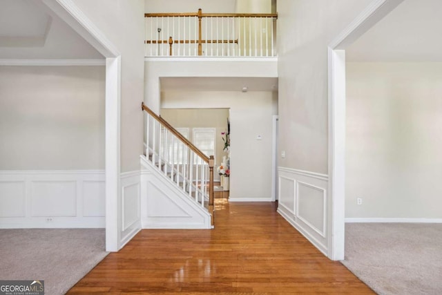 1520 Ethans Way, Mcdonough, GA 30252 - carpeted foyer entrance featuring stairway, a decorative wall, a wainscoted wall, and wood finished floors