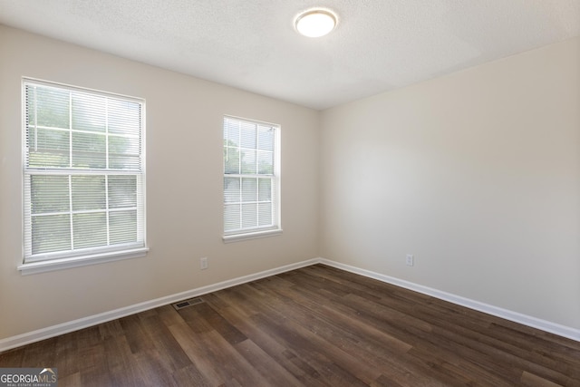 empty room with dark wood finished floors and baseboards
