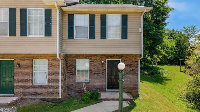 view of front facade with brick siding and a front yard
