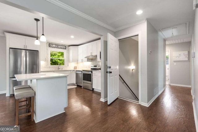 3890 Cherrydale Ln SE, Smyrna, GA 30082 - kitchen featuring stainless steel appliances, under cabinet range hood, backsplash, white cabinets, and ornamental molding