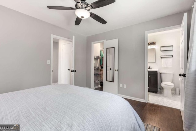 3890 Cherrydale Ln SE, Smyrna, GA 30082 - bedroom featuring dark wood finished floors, a walk in closet, connected bathroom, baseboards, and a closet