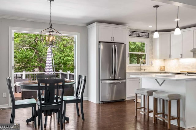 3890 Cherrydale Ln SE, Smyrna, GA 30082 - kitchen with freestanding refrigerator, healthy amount of natural light, light countertops, white cabinets, and ornamental molding
