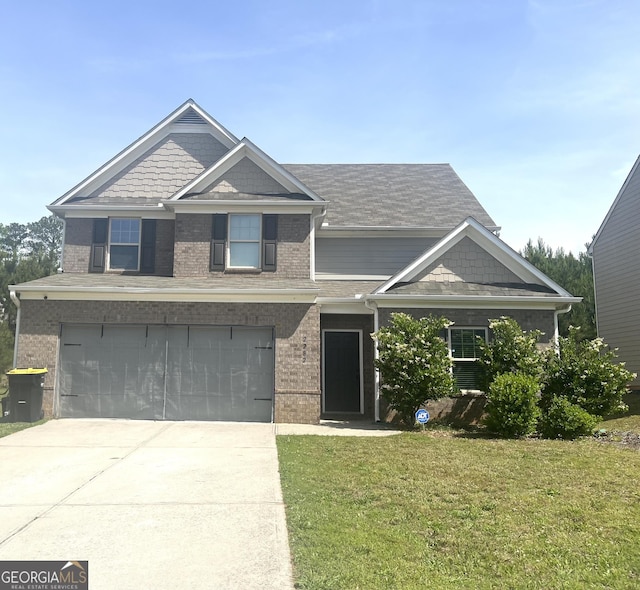 craftsman-style home featuring brick siding, a front yard, an attached garage, and concrete driveway