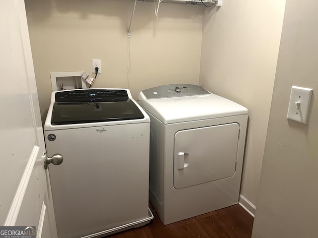 clothes washing area with washing machine and clothes dryer and dark wood-type flooring