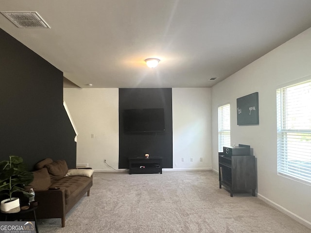 carpeted living area with baseboards