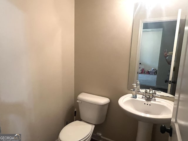 half bath with toilet and a sink