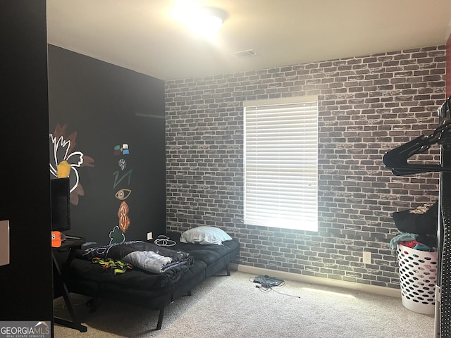 bedroom with brick wall and carpet flooring