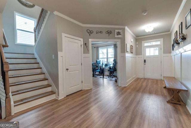 592 Eagles Nest Cir, Auburn, GA 30011 - foyer entrance with light wood-type flooring, stairs, wainscoting, crown molding, and a decorative wall