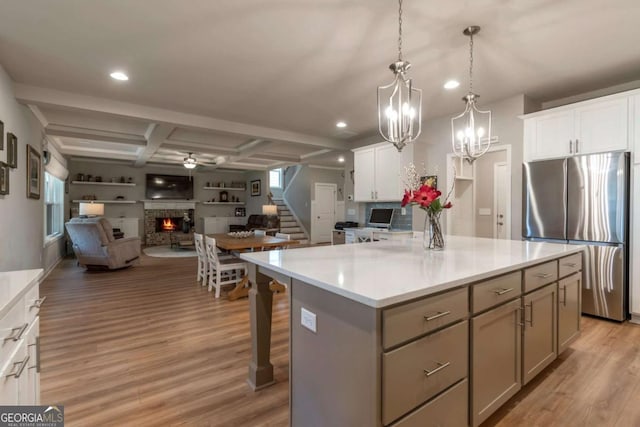 592 Eagles Nest Cir, Auburn, GA 30011 - kitchen with freestanding refrigerator, open floor plan, a lit fireplace, coffered ceiling, and light wood-style flooring