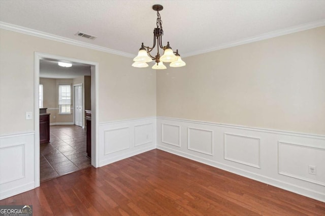 500 Wyckfield Way, Hinesville, GA 31313 - empty room with a chandelier, dark wood-style floors, crown molding, wainscoting, and a decorative wall