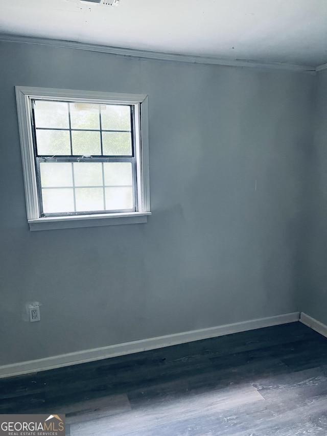 spare room with baseboards, wood finished floors, and ornamental molding