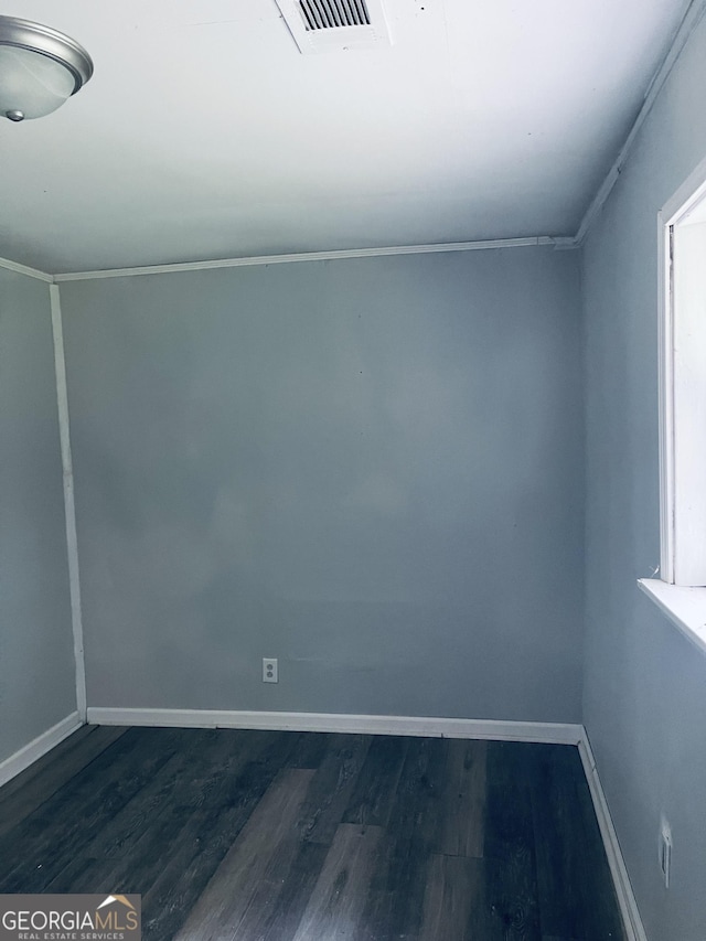 spare room with dark wood-type flooring and baseboards
