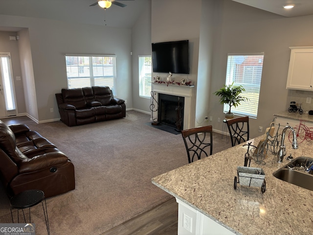 457 Panhandle Pl, Hampton, GA 30228 - living area featuring ceiling fan, a fireplace with flush hearth, baseboards, lofted ceiling, and dark carpet