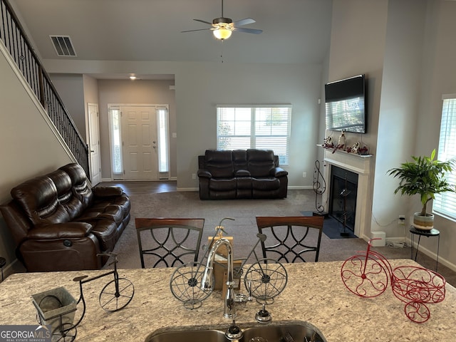 457 Panhandle Pl, Hampton, GA 30228 - living room with carpet flooring, baseboards, a fireplace with flush hearth, and high vaulted ceiling
