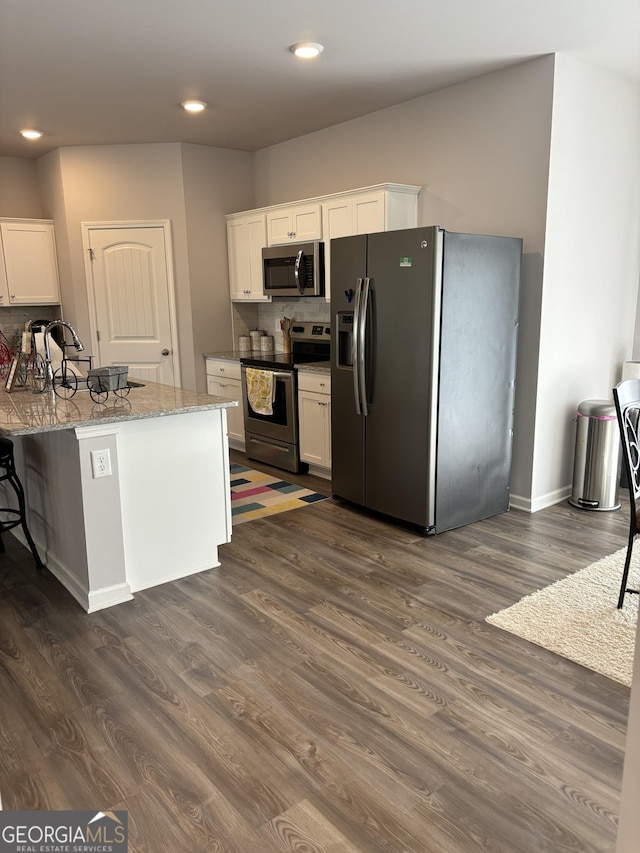 457 Panhandle Pl, Hampton, GA 30228 - kitchen featuring stainless steel appliances, white cabinetry, dark wood-style flooring, light stone counters, and recessed lighting