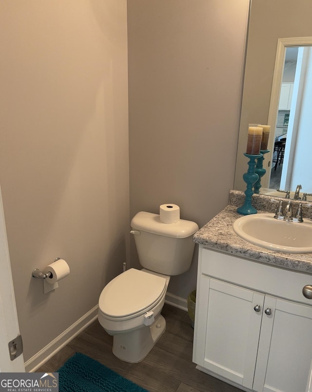 457 Panhandle Pl, Hampton, GA 30228 - half bathroom featuring wood finished floors, toilet, vanity, and baseboards