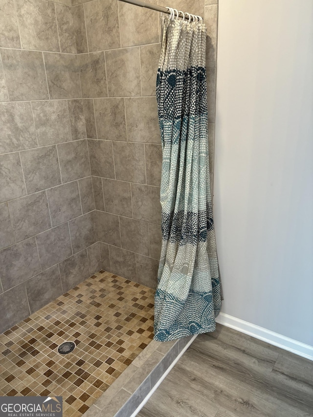 457 Panhandle Pl, Hampton, GA 30228 - bathroom with a shower stall, wood finished floors, and baseboards